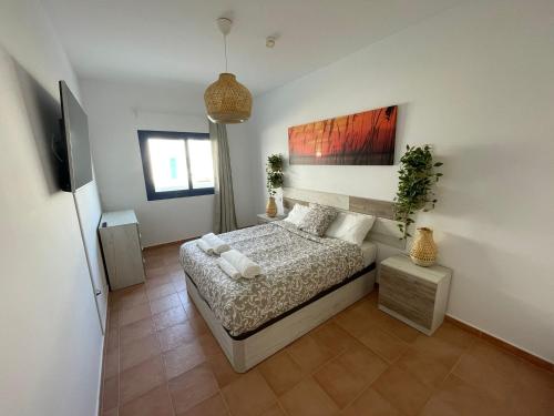 una camera da letto con un letto e un dipinto sul muro di Casa Fuerteventura a Costa Calma
