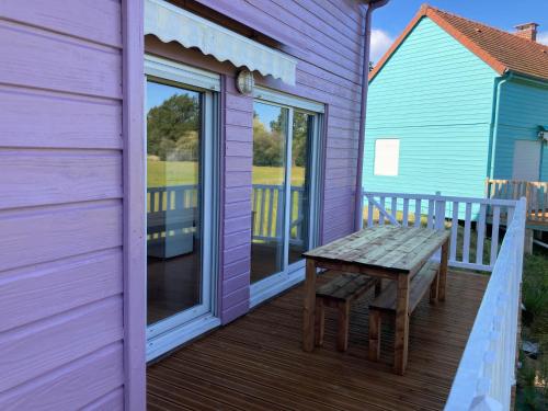 a purple house with a wooden bench on a deck at Domaine de la roselière • Nature • Brenne in Rosnay