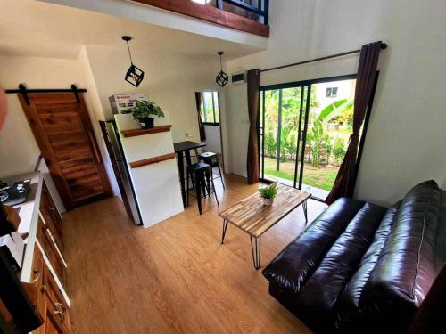 a living room with a leather couch and a table at S&S House in Srithanu