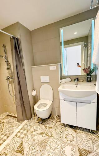 La salle de bains est pourvue de toilettes, d'un lavabo et d'un miroir. dans l'établissement Chakvi Sunset, à Chakvi