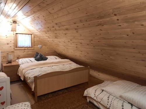 a bedroom with two beds in a log cabin at Holiday house Radić in Sošice