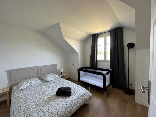 1 dormitorio con 1 cama con sombrero en Chez KS, cottage au calme proche d'Orléans, en Ardon