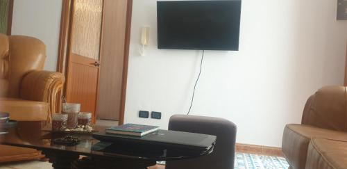 a living room with a table and a flat screen tv at Hills Villa in Vlorë