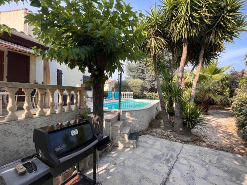 une télévision sur un support à côté d'une maison avec piscine dans l'établissement Maison familiale classée 3 Etoile - Clim & Piscine privée -, à La Farlède