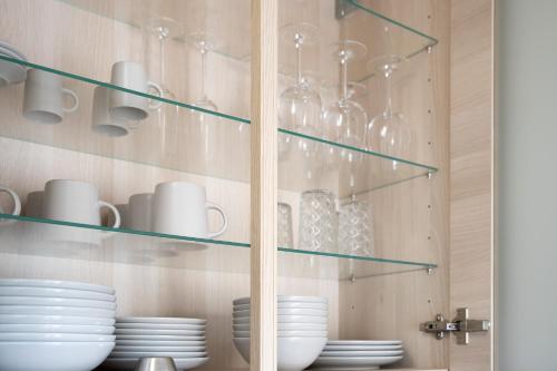 a glass display cabinet with plates and dishes in it at CARICASA Stylisches Apartment in der Nähe von Nürnberg in Schwarzenbruck