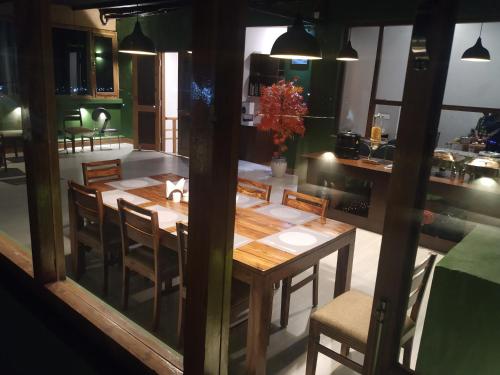 列城的住宿－Maple house ladakh，一间带木桌和椅子的用餐室