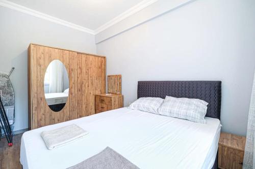 um quarto com uma cama branca e um espelho em Palmiye Apart Hotel em Antalya