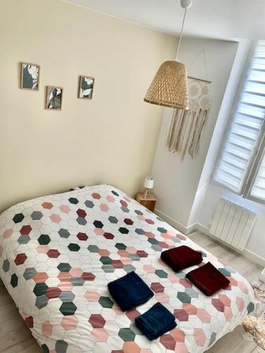 une chambre avec un lit avec une couette colorée dans l'établissement Appartement chaleureux aux portes de Bordeaux, à Macau
