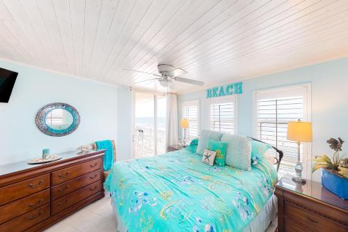 um quarto com uma cama, uma cómoda e janelas em The Oceans Edge em North Topsail Beach