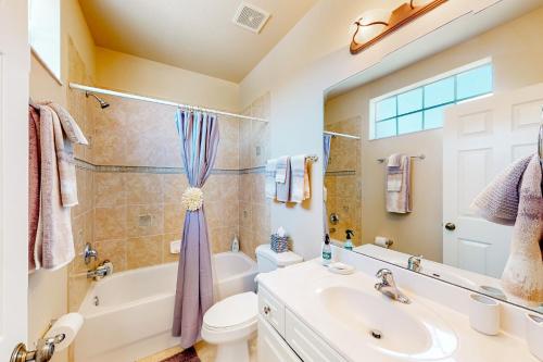 y baño con lavabo, bañera y aseo. en Coastal Serenity Retreat en Fort Myers