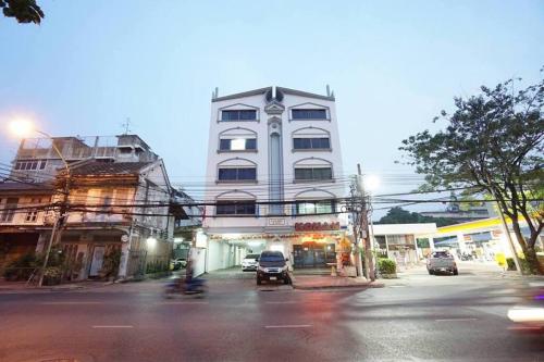 a tall white building with cars parked in front of it at Maruay Living Apartment 506 (Khaosan/Chinatown/Samyot MRT) in Bangkok