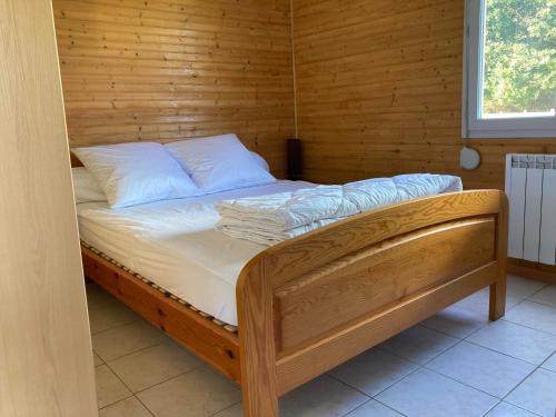 a bed in a room with a wooden wall at Domaine de la roselière • Nature • Brenne in Rosnay
