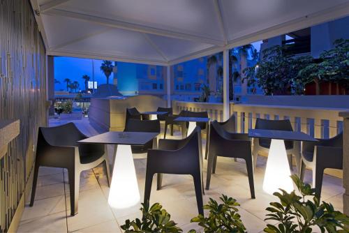 a restaurant with tables and chairs on a balcony at Elba Motril Beach & Business Hotel in Motril
