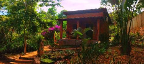 a small house in the middle of a garden at Pousada Luar do Sertão in Lençóis