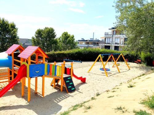 un parque infantil con un colorido equipo de juegos en la arena en Forest Hill apartment en Budapest