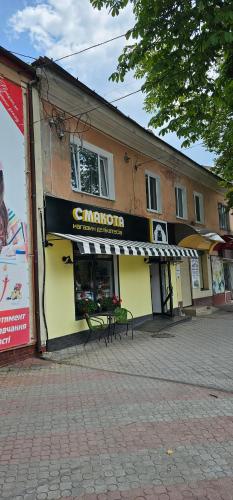 a store with a sign on the side of a building at Апартаменти на Лесі Українки Центр 5хв Старе місто Парк in Kamianets-Podilskyi