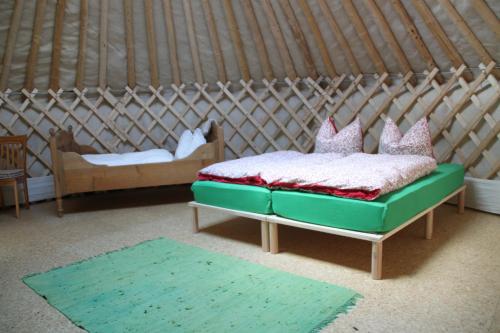 a bed in a yurt with two chairs and a bed sidx sidx at Kirgisische Jurte der Hofmühle Pfaffroda in Olbernhau