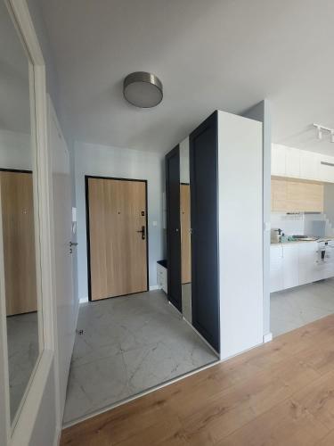 an empty room with two sliding doors and a kitchen at Baltika in Gdańsk