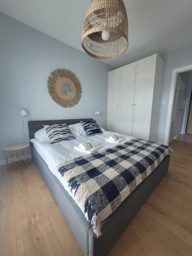 a bedroom with a bed with a checkered blanket at Baltika in Gdańsk
