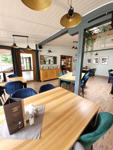 ein Esszimmer mit Holztischen und blauen Stühlen in der Unterkunft Zajazd Wernyhora in Sułoszowa