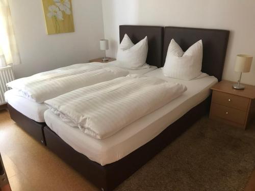 sypialnia z 2 łóżkami z białą pościelą i poduszkami w obiekcie Landhaus Kraehenberg w mieście Niedersalwey