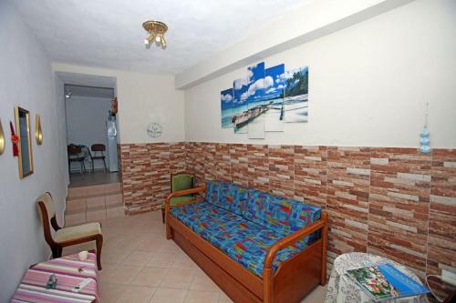 a bedroom with a bed and a brick wall at Paraporti Room 2 in Andros