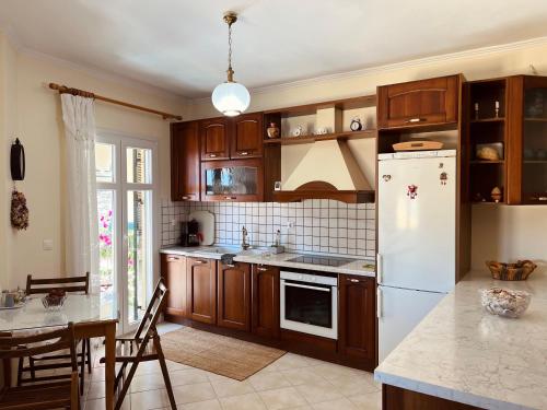 a kitchen with wooden cabinets and a white refrigerator at Marina's House in Parga