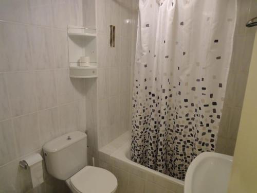a bathroom with a toilet and a shower curtain at Jardin Calpe Apartment in Calpe