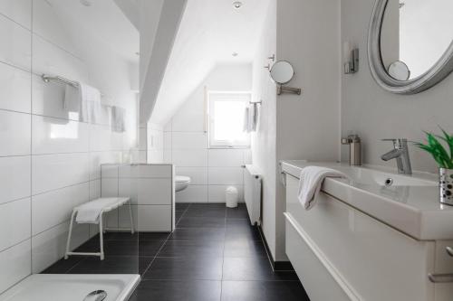 W białej łazience znajduje się umywalka i lustro. w obiekcie Landhaus Salweytal w mieście Niedersalwey