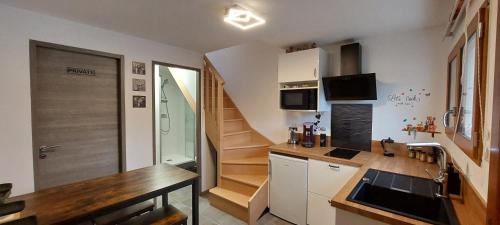 una pequeña cocina con fregadero y una escalera en Studio duplex à Savenay en Savenay