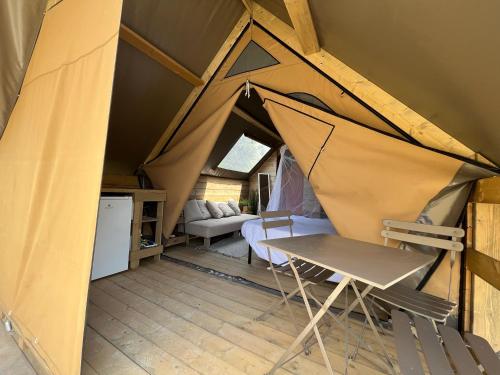 Tienda de campaña con mesa y silla en una habitación en Glamping Tuscany - Podere Cortesi, en Santa Luce