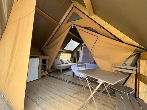 a tent with a table and a chair in a room at Glamping Tuscany - Podere Cortesi in Santa Luce