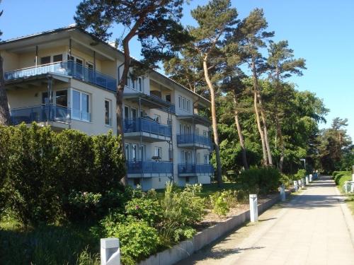 ein Apartmenthaus mit blauen Balkonen auf einer Straße in der Unterkunft Apartment "oceanview" in Lubmin