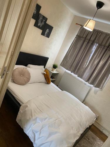 białe łóżko w sypialni z oknem w obiekcie 2 Bedroom Flat Available To Let w mieście Abbey Wood