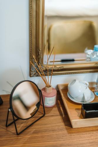 a mirror sitting on a table next to a plate at Hotel Nais in Niš
