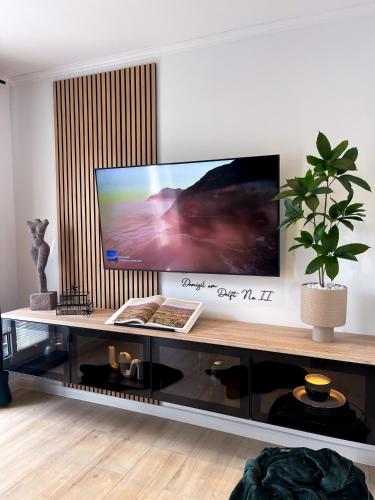 a large flat screen tv sitting on top of a table at Ferienwohnung Domizil am Delft II Emden in Emden
