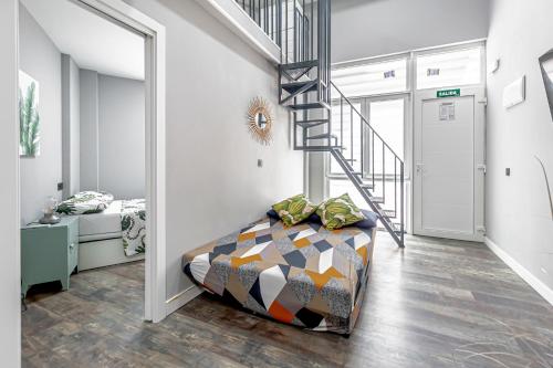 korytarzem ze schodami i łóżkiem w pokoju w obiekcie Luminoso cerca 4 Caminos- Apartamento REINA VICTORIA w Madrycie