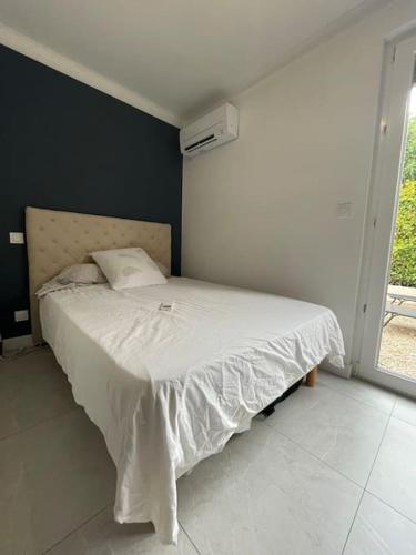 a bedroom with a bed in a room with a window at Appt 1 chambre jardin parking in Narbonne