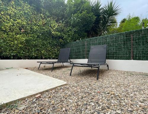 two black chairs sitting next to a fence at Appt 1 chambre jardin parking in Narbonne
