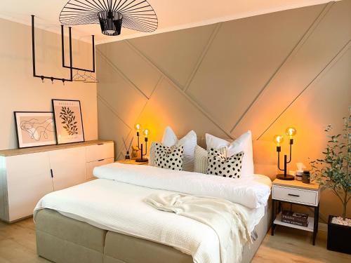 dwa łóżka w sypialni z oświetleniem w obiekcie Ferienwohnung Domizil am Delft II Emden w mieście Emden