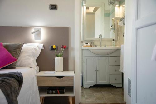 1 dormitorio con cama, lavabo y espejo en Locanda agli Amici, en Cortona