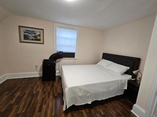 sypialnia z białym łóżkiem i oknem w obiekcie Sunflower Guest Suites w mieście Summerside