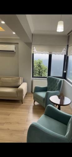 uma sala de estar com um sofá, cadeiras e uma mesa em Mükemmel doğa manzaralı villa. em Macka