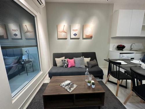 uma sala de estar com um sofá e uma mesa em Arte Mont Kiara Pool View em Kuala Lumpur