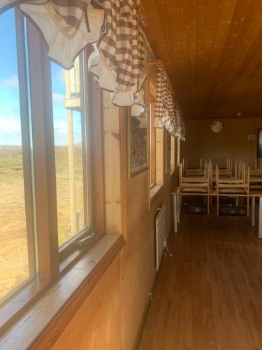 um quarto com janelas e uma sala de jantar com uma mesa em Gíslaskáli em Bergsstaðir