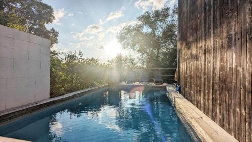 a swimming pool with the sun in the background at Maison à la porte des Ardennes in Verviers