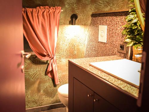 a bathroom with a sink and a toilet and a curtain at PARADISE RANCH in Borgo Sabotino