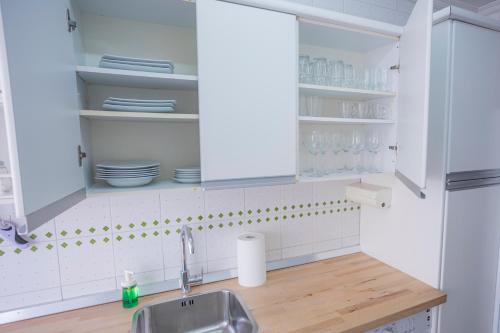 una cocina con armarios blancos y fregadero en Apartamento Parque Mediterráneo, en Málaga