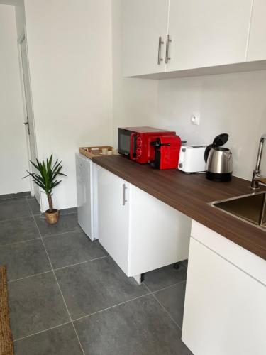 a kitchen with a counter with a red appliance on it at Tiny house 4 min drive to Cdg airport in Roissy-en-France