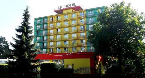 a large yellow hotel with a sign on top of it at ABC Hotel Nitra in Nitra